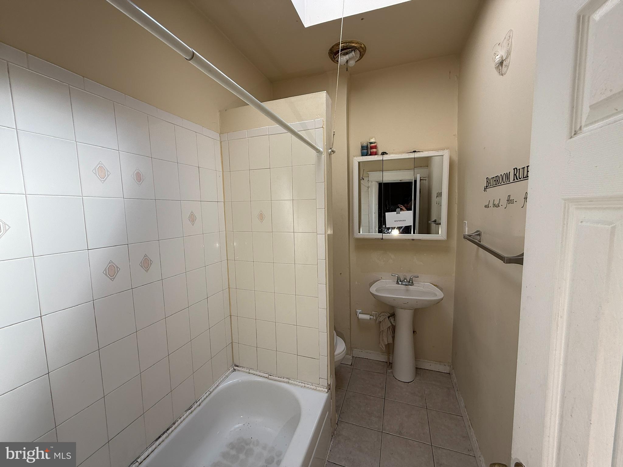 406 Edgewood Street Baltimore, MD 21229 - Photo 9 of 12 a bathroom with a sink a toilet and shower