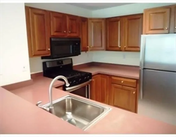 a kitchen with granite countertop a refrigerator and a sink