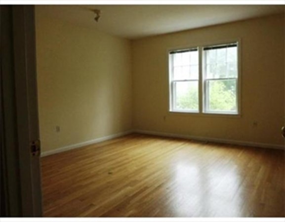 12 N Commons, Unit L Lincoln, MA 01773 - Photo 18 of 25 an empty room with wooden floor and windows