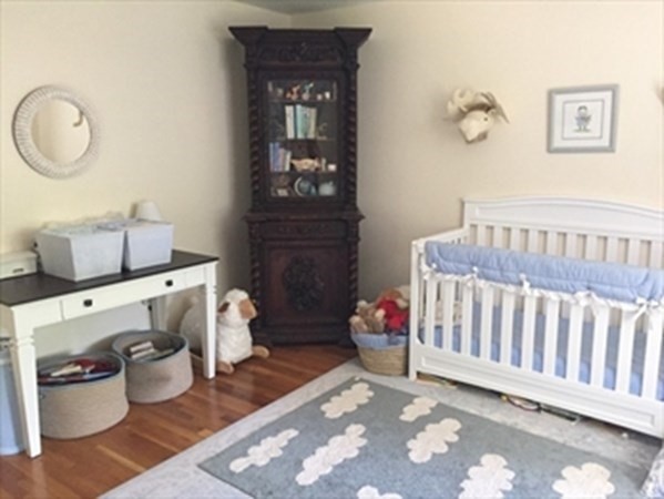 12 N Commons, Unit L Lincoln, MA 01773 - Photo 19 of 25 a bedroom with a baby crib and a couch