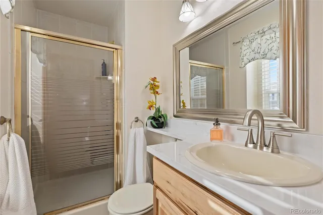 a bathroom with a granite countertop sink toilet and shower
