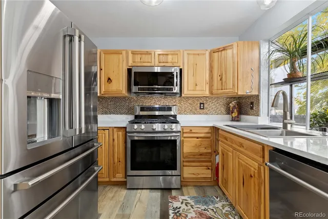 a kitchen with stainless steel appliances a stove sink and microwave