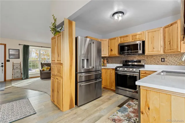 a kitchen with stainless steel appliances granite countertop a refrigerator stove and sink