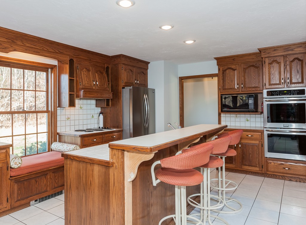 30 Main Road Montgomery, MA 01085 - Photo 12 of 30 a kitchen with stainless steel appliances kitchen island granite countertop a table chairs stove refrigerator and cabinets