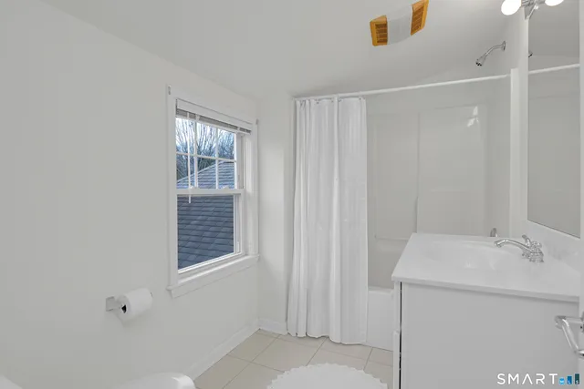 a bathroom with a sink vanity and a window