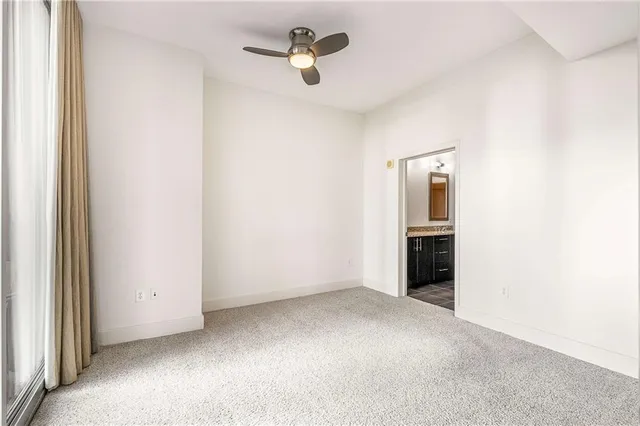 a view of a livingroom with an empty space a flat screen tv and staircase