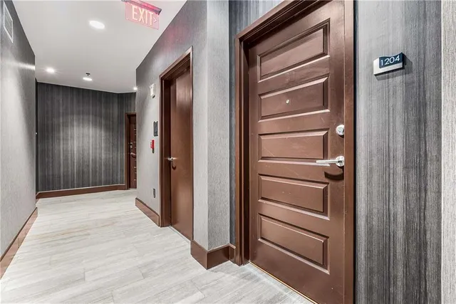 a view of a hallway with wooden floor and staircase