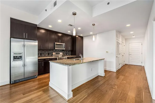a view of a room with a ceiling fan and refrigerator