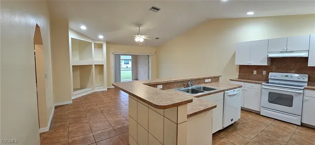a kitchen that has a sink a stove and a refrigerator