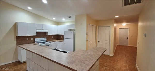 a kitchen with a refrigerator a sink and cabinets