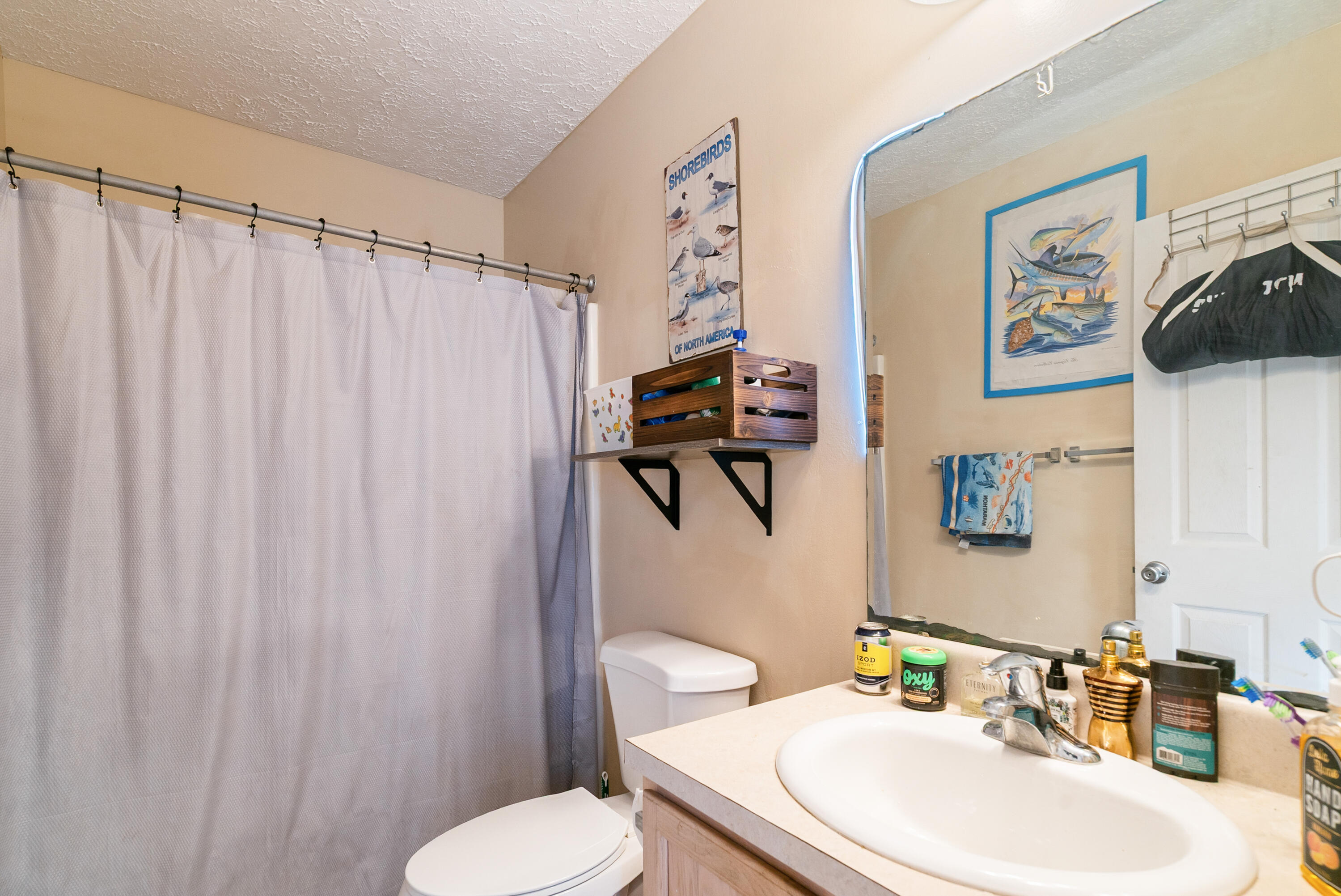 192 2nd Court Key Largo, FL 33037 - Photo 17 of 44 a bathroom with a sink a toilet and shower curtain