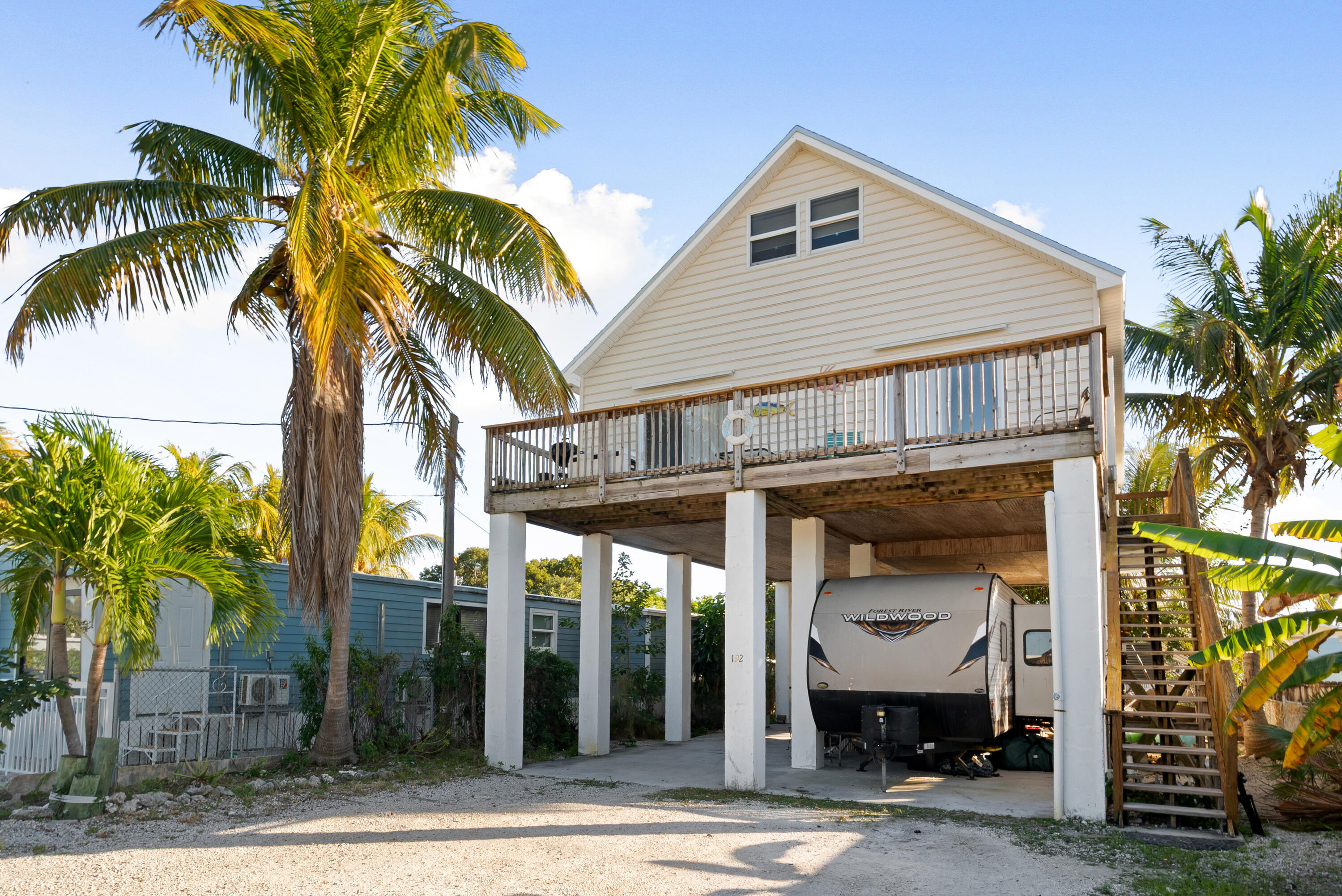192 2nd Court Key Largo, FL 33037 - Photo 2 of 44 a front view of a house with glass windows and a palm tree