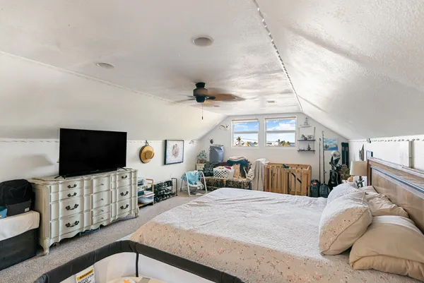 a bedroom with bed and flat tv screen