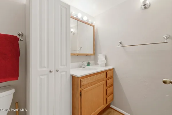 a utility room with a sink a toilet and a mirror