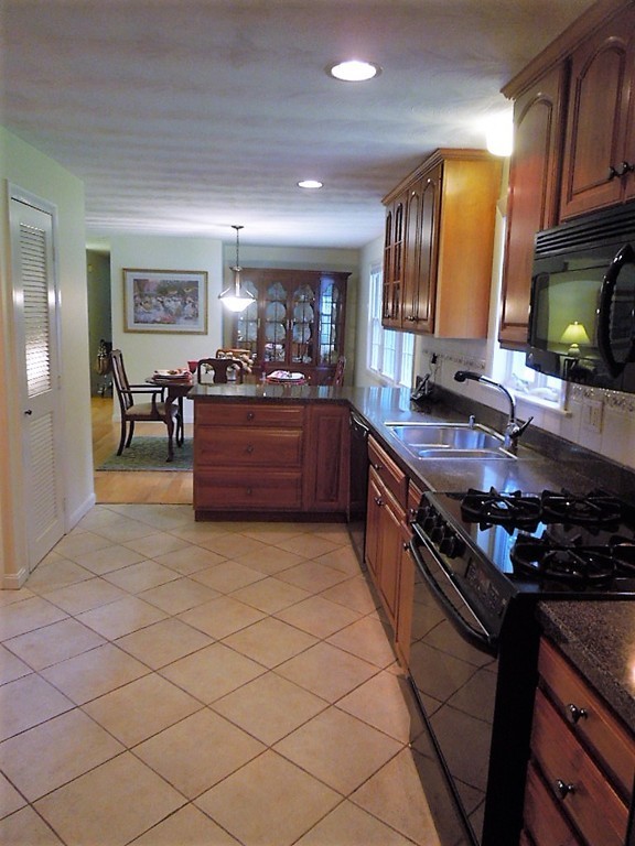 8 Howard Road Chelmsford, MA 01824 - Photo 12 of 30 a kitchen with stainless steel appliances granite countertop a stove a sink and a refrigerator