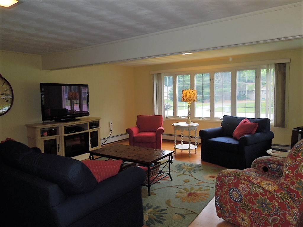 8 Howard Road Chelmsford, MA 01824 - Photo 4 of 30 a living room with furniture a large window and a flat screen tv