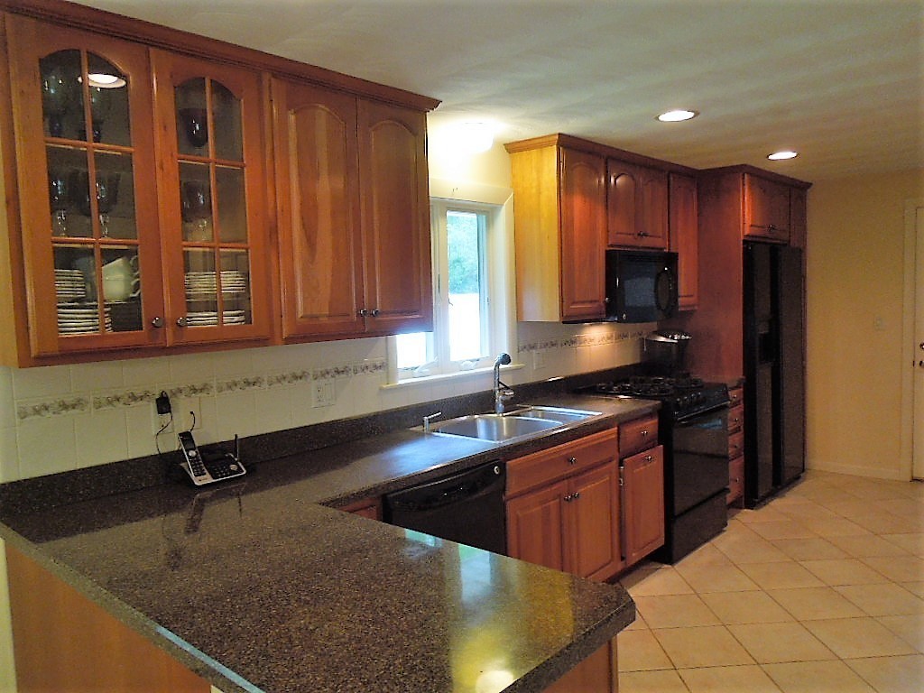 8 Howard Road Chelmsford, MA 01824 - Photo 9 of 30 a kitchen with stainless steel appliances granite countertop a sink stove and cabinets