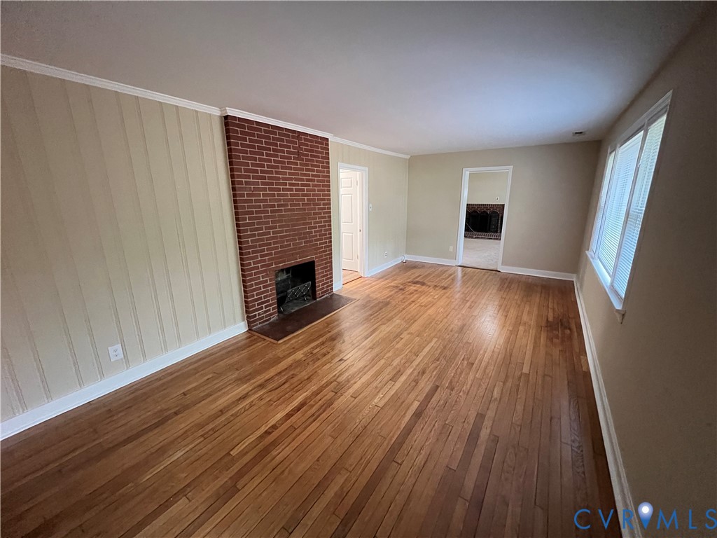 901 Ridgecliff Drive Richmond, VA 23224 - Photo 2 of 8 a view of empty room with wooden floor and fireplace