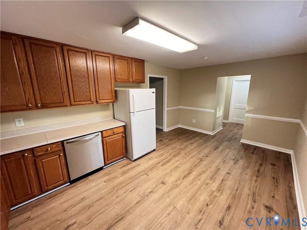 901 Ridgecliff Drive Richmond, VA 23224 - Photo 3 of 8 a kitchen with wooden floors and white walls