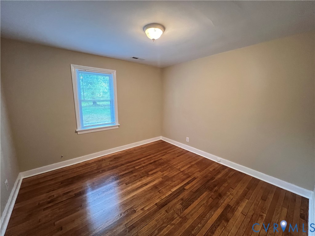 901 Ridgecliff Drive Richmond, VA 23224 - Photo 4 of 8 a view of an empty room with wooden floor and a window