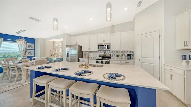 a living room with stainless steel appliances kitchen island granite countertop furniture a refrigerator and a view of living room