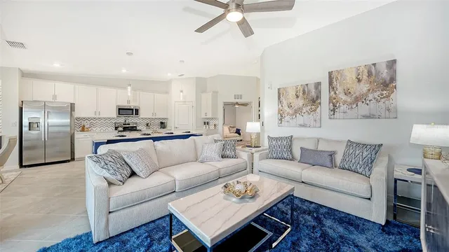 a kitchen with a sink a stove a refrigerator and white cabinets