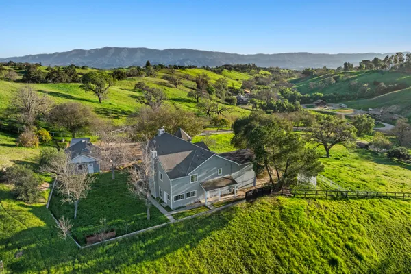 an aerial view of residential house with an outdoor space and seating