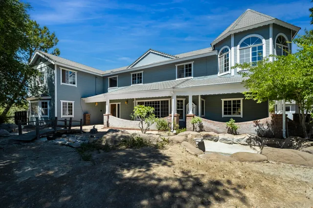 a front view of a house with a yard outdoor seating and covered with green space