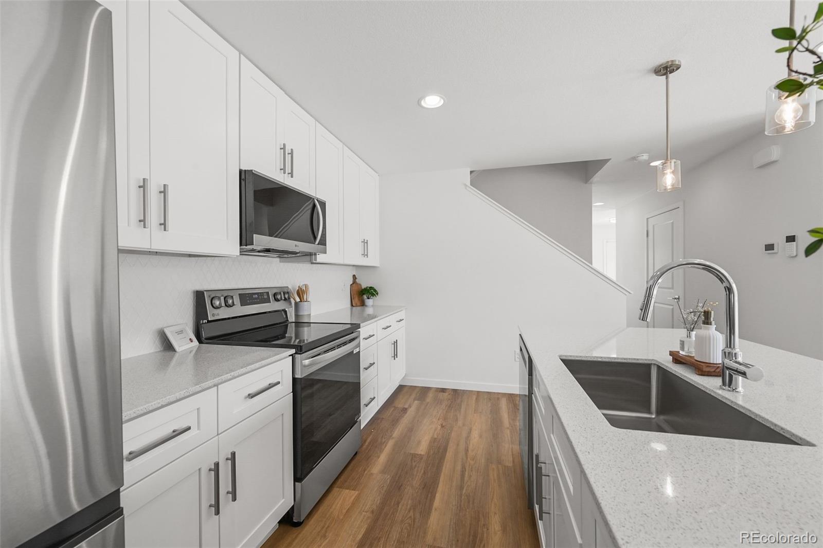 1304 Akron Street Aurora, CO 80010 - Photo 11 of 28 a kitchen with sink a microwave and cabinets