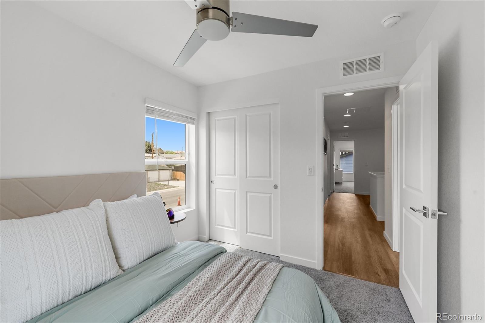 1304 Akron Street Aurora, CO 80010 - Photo 17 of 28 a bedroom with a bed and a chandelier