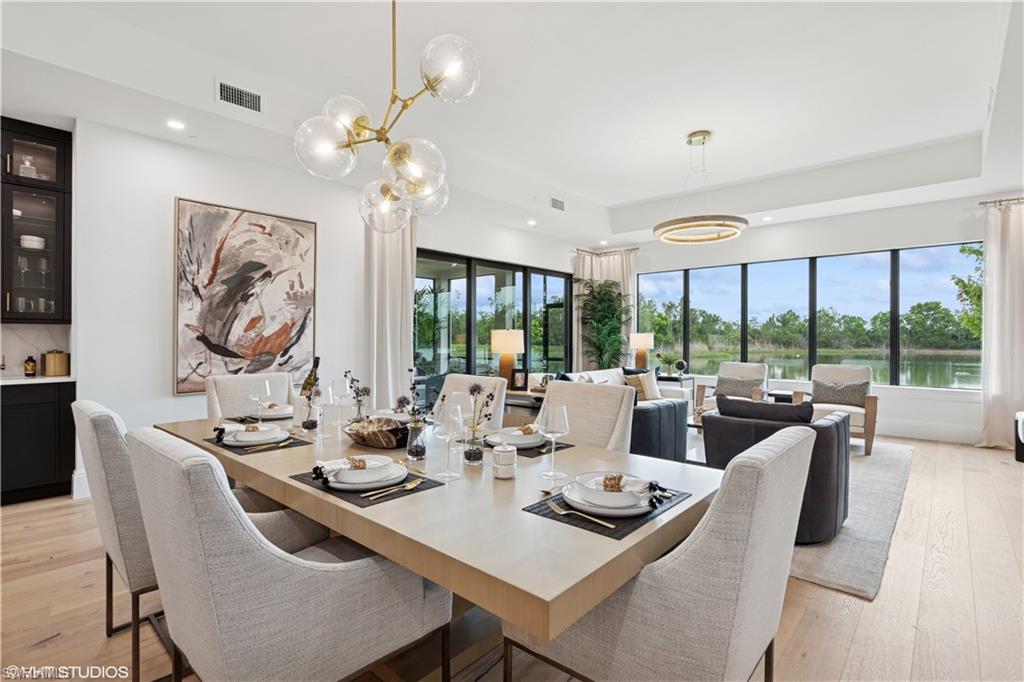 19781 Marino Lake Circle, Unit B4101 Miromar Lakes, FL 33913 - Photo 13 of 44 a dining room with furniture a large window and a chandelier
