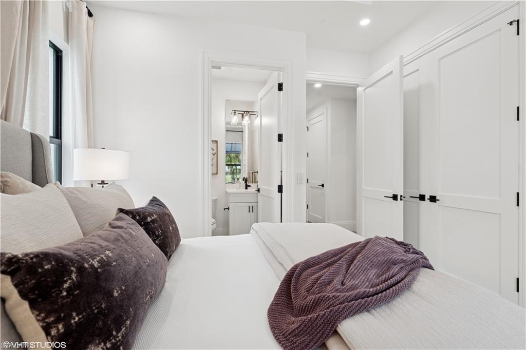 19781 Marino Lake Circle, Unit B4101 Miromar Lakes, FL 33913 - Photo 39 of 44 a bedroom with a bed a mirror and a dresser