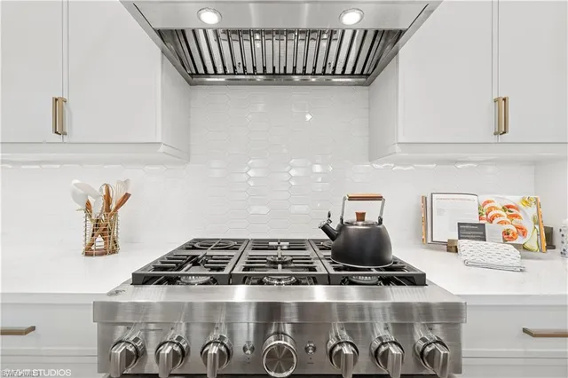 a kitchen with a stove and a white cabinets