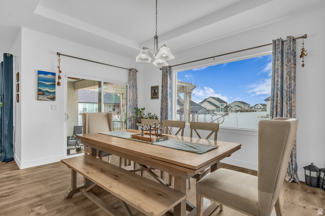 2454 West Jackson Street Mapleton, UT 84664 - Photo 12 of 63 Dining area featuring a raised ceiling, suspended lighting, wood finished floors, and a residential view