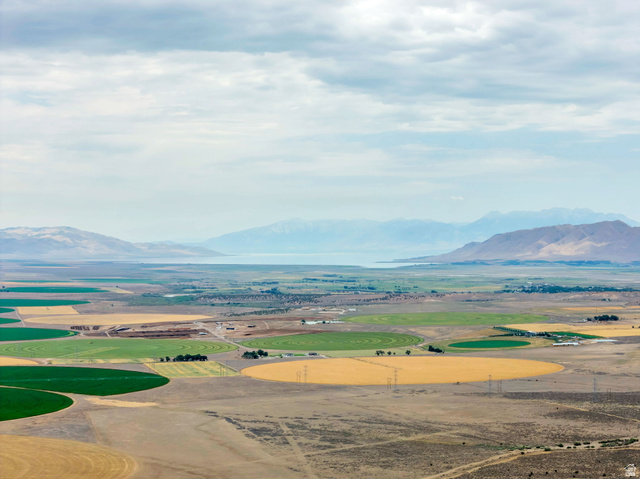 12800 South Crooked Cyn Road South Elberta, UT 84626 - Photo 16 of 48 Expansive agricultural landscape featuring circular fields with varying crops, distant mountains, and a visible body of water