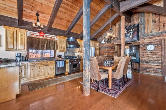 a dining room with stainless steel appliances wooden floors and view