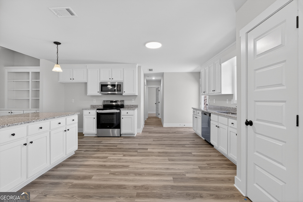 140 Chad Walk, Unit 57 Statham, GA 30666 - Photo 11 of 36 a large kitchen with cabinets wooden floor and stainless steel appliances