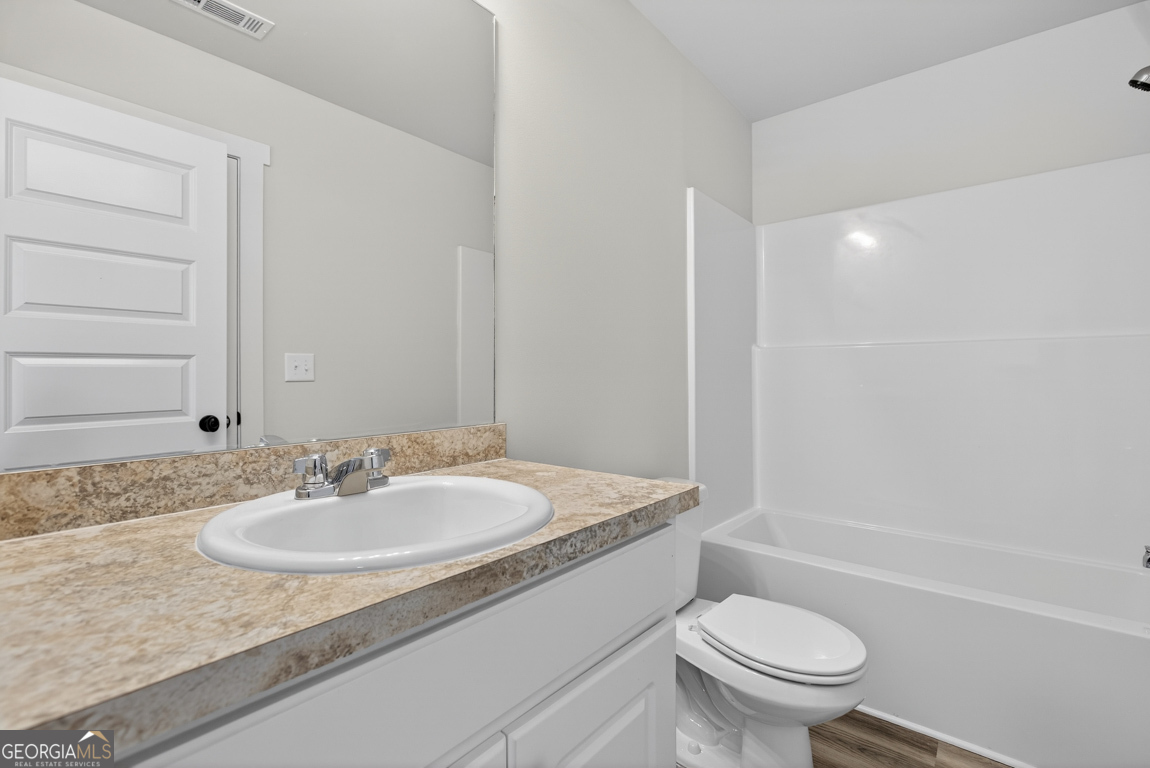 140 Chad Walk, Unit 57 Statham, GA 30666 - Photo 19 of 36 a bathroom with a granite countertop sink a toilet and a bathtub