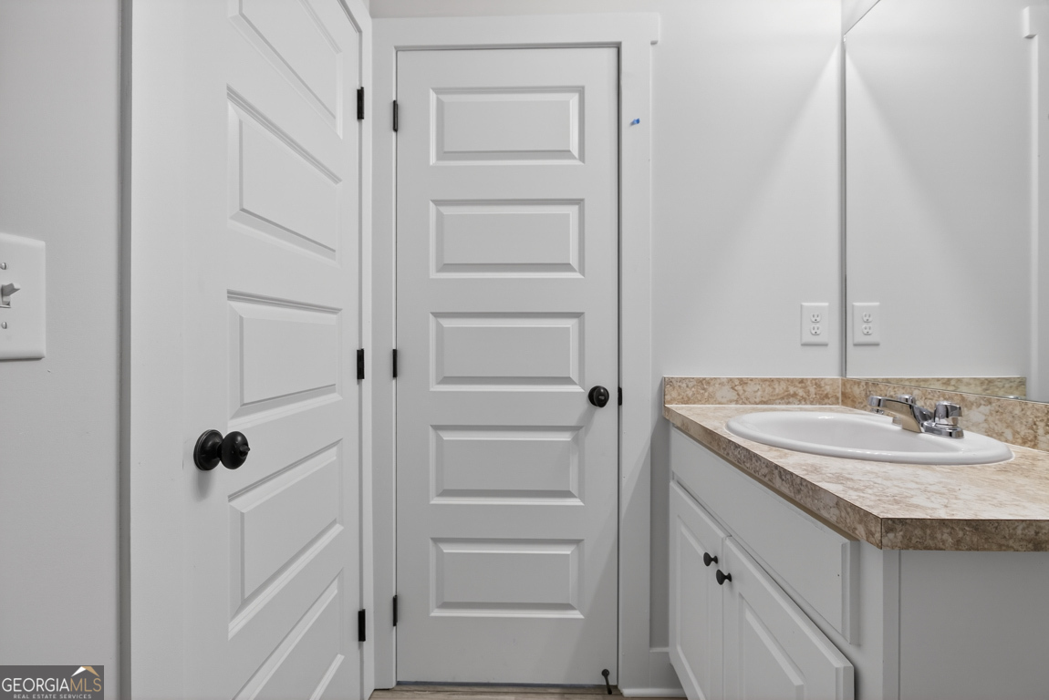140 Chad Walk, Unit 57 Statham, GA 30666 - Photo 20 of 36 a bathroom with a granite countertop sink and a mirror
