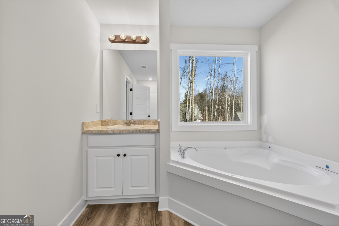 140 Chad Walk, Unit 57 Statham, GA 30666 - Photo 32 of 36 a bathroom with a tub sink and mirror