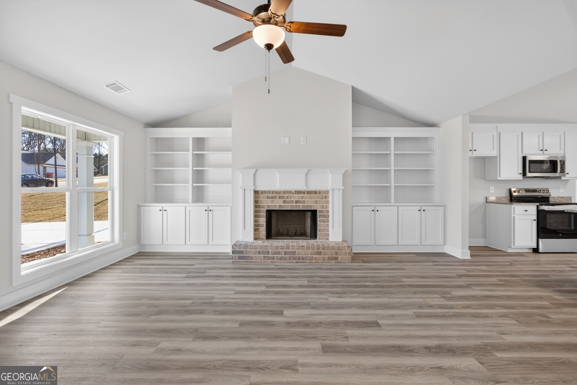 140 Chad Walk, Unit 57 Statham, GA 30666 - Photo 4 of 36 a view of a livingroom with wooden floor a ceiling fan and windows