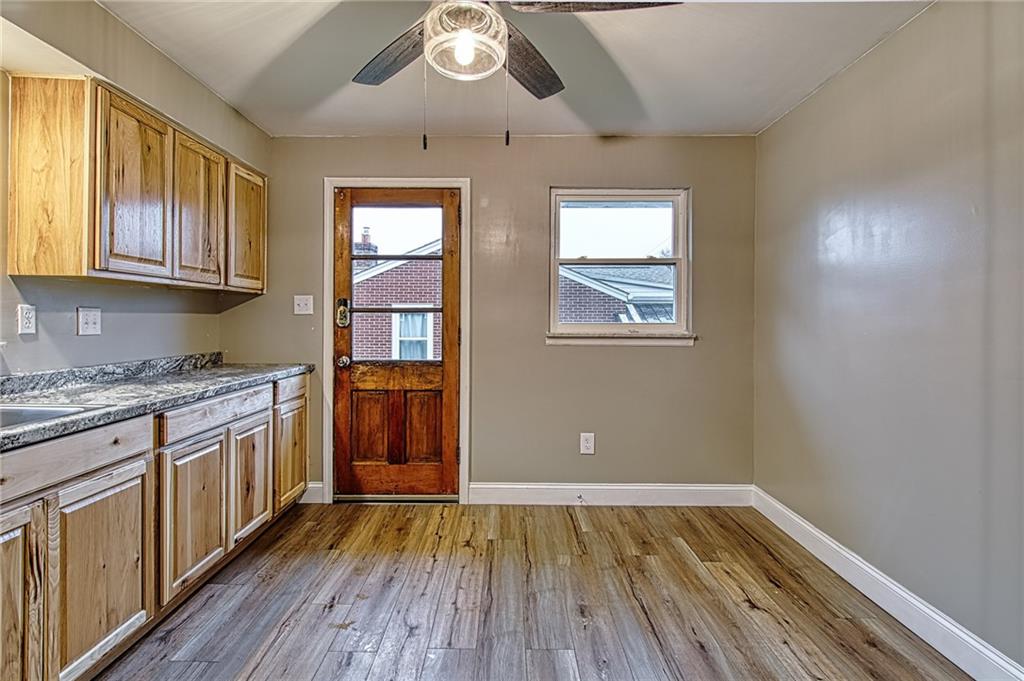 613 Virginia Avenue Rochester, PA 15074 - Photo 7 of 21 a kitchen with granite countertop wooden floors and stainless steel appliances
