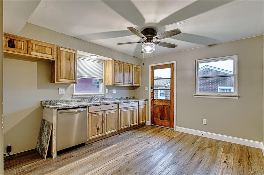 613 Virginia Avenue Rochester, PA 15074 - Photo 8 of 21 a kitchen with stainless steel appliances granite countertop hardwood floor sink stove and wooden cabinets