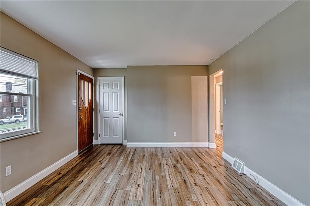 613 Virginia Avenue Rochester, PA 15074 - Photo 9 of 21 a view of an empty room with wooden floor and a window