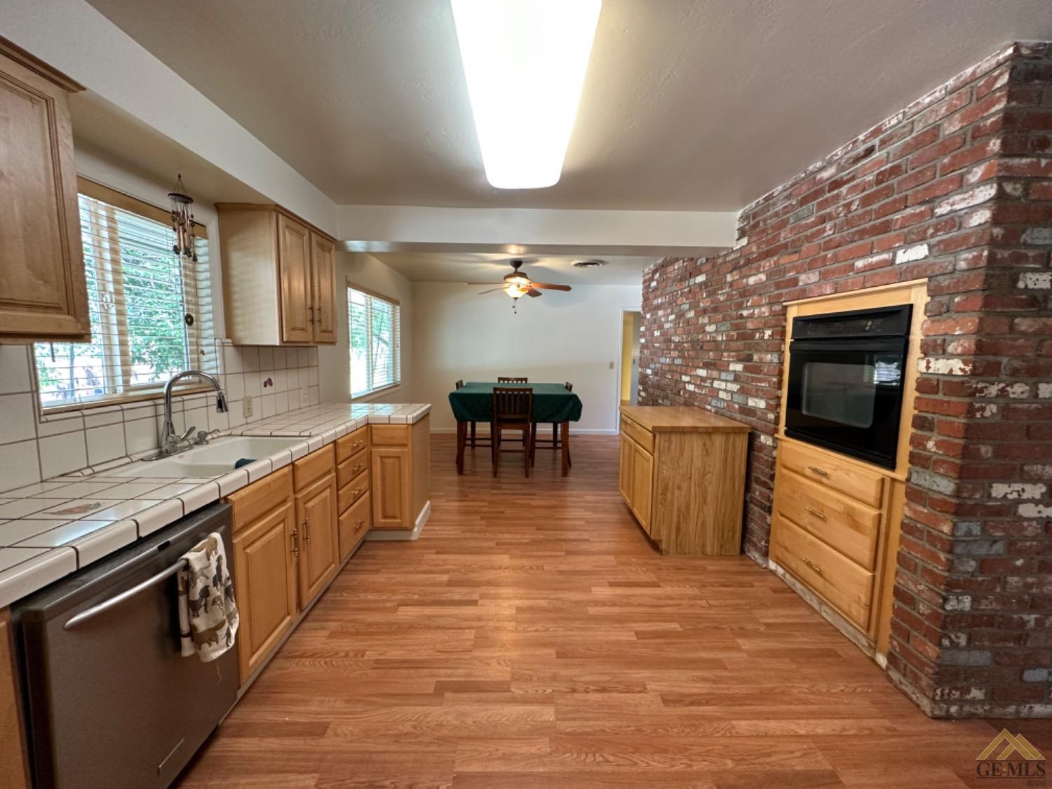 Undisclosed Address Caliente, CA 93518 - Photo 9 of 59 a large kitchen with stainless steel appliances granite countertop a stove top oven a sink dishwasher a dining table and chairs with wooden floor