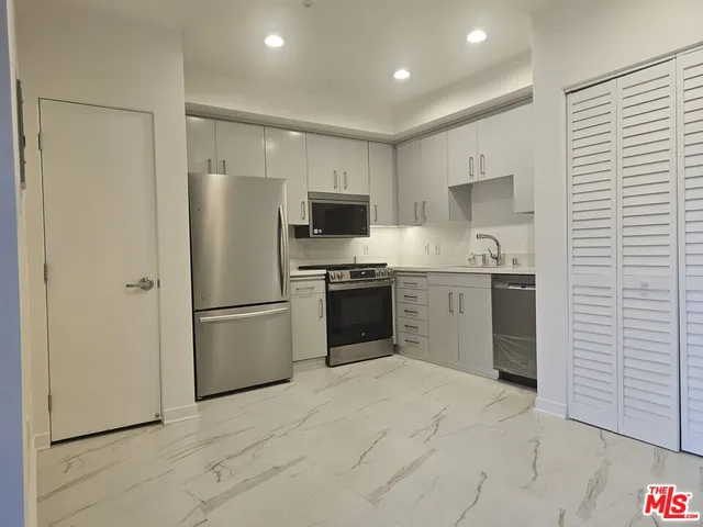 a kitchen with a refrigerator a sink and a stove