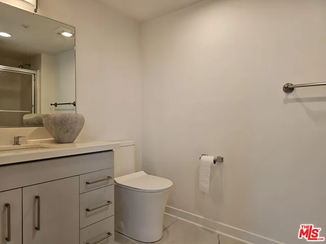 a bathroom with a toilet a sink and mirror