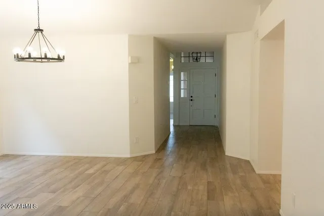 a view of a hallway with wooden floor and a bathroom