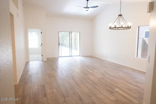 a view of an empty room with wooden floor and closet