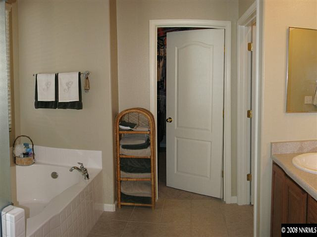2372 Copper Springs Drive Reno, NV 89521 - Photo 7 of 9 a bathroom with a tub a sink and a large mirror